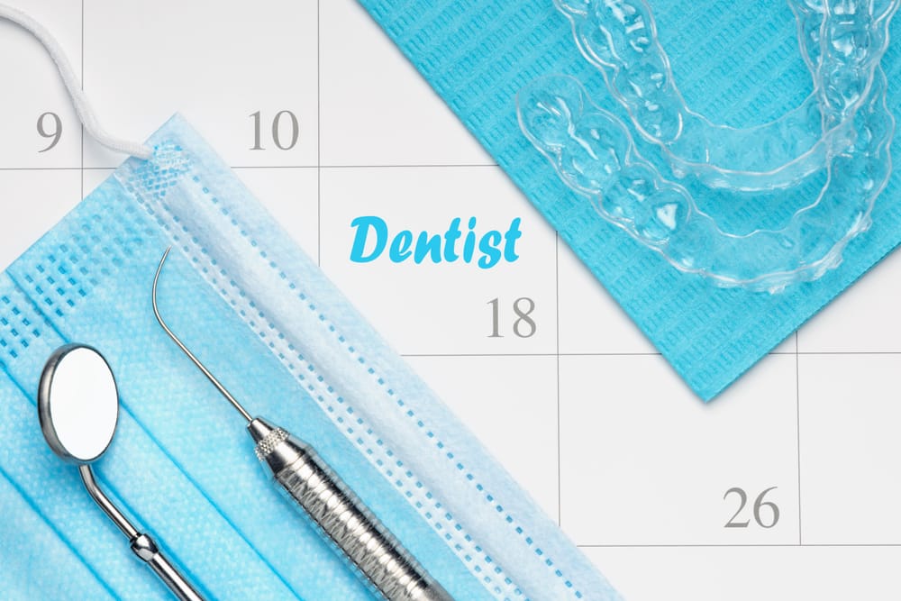 Invisalign trays and dental instruments with a calendar background