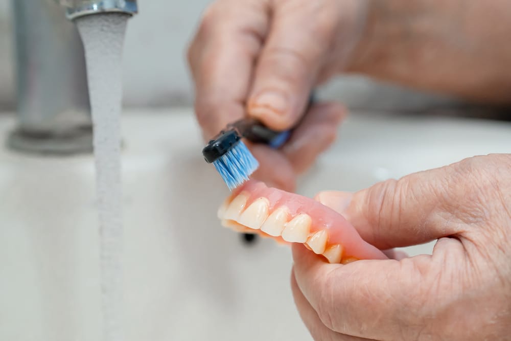 A man brushes his dentures